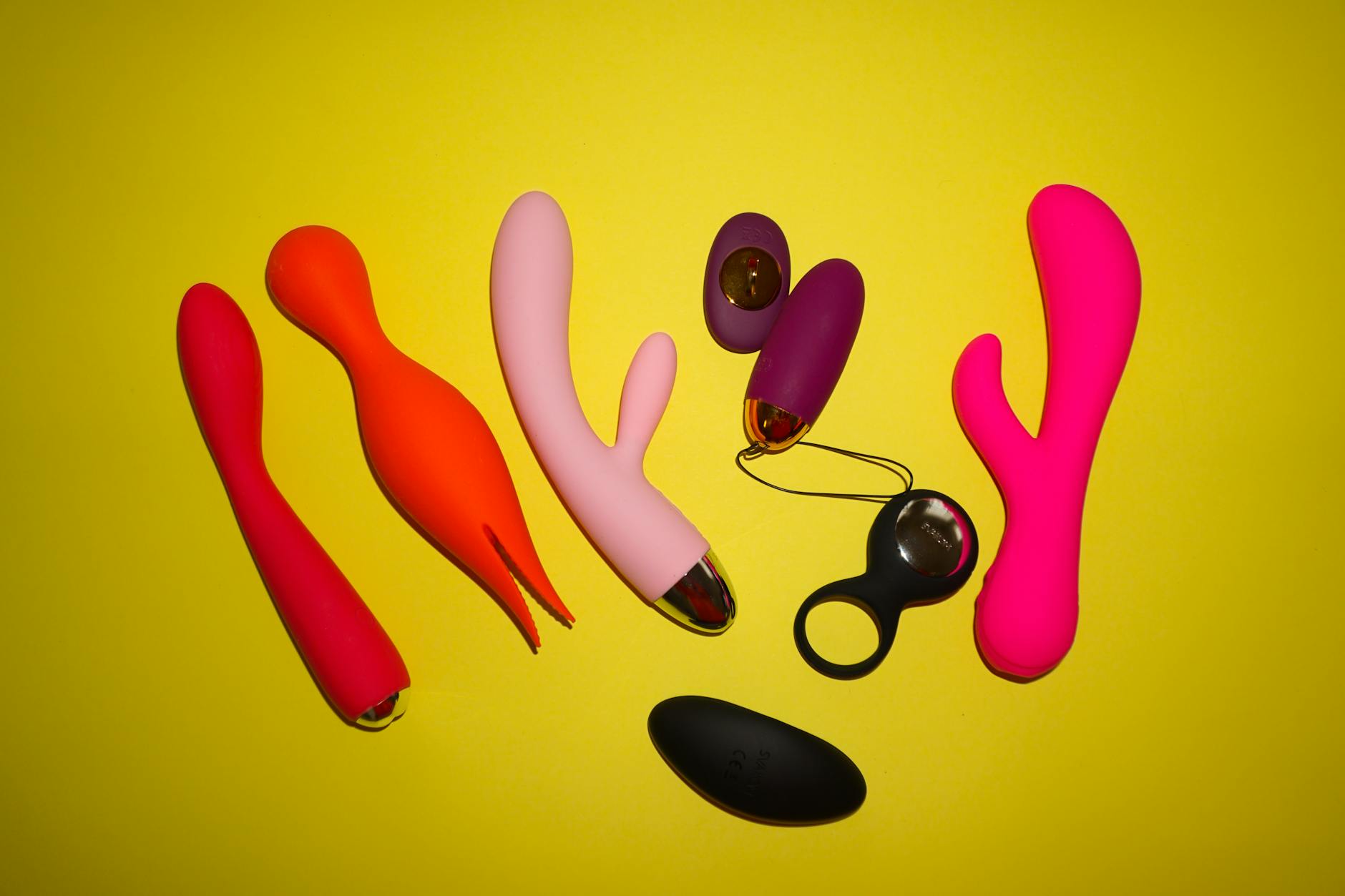 Colorful lemon vibrators and adult toys on bright yellow background